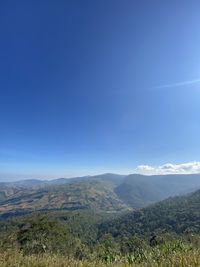 Scenic view of mountains against blue sky