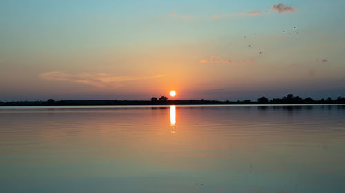 Scenic view of lake against sky during sunset