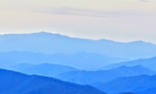 Scenic view of mountains against blue sky