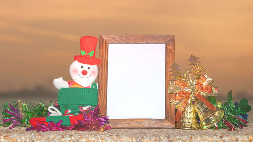 Close-up of blank picture frame with christmas decorations on table