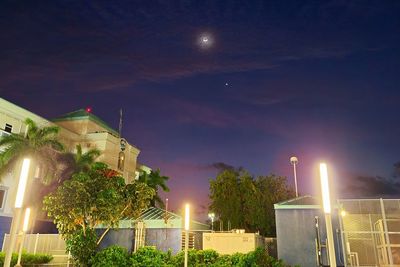 Low angle view of illuminated buildings against sky at night