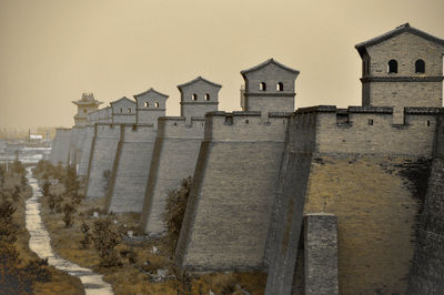 Exterior of castle against clear sky during sunset