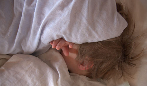 High angle view of woman sleeping on bed