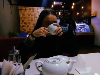 Midsection of man holding coffee cup on table in restaurant