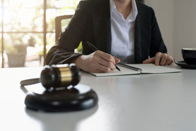 Midsection of businessman working on table