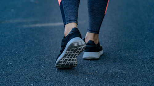 Low section of woman standing on road