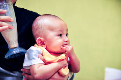 Midsection of woman drinking by son in restaurant