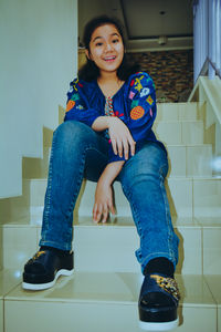 Portrait of a smiling young woman sitting at home