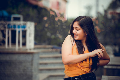 Young woman looking at camera while standing outdoors