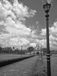 Street light by building against sky