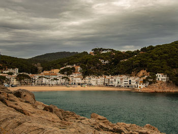 Scenic view of sea by buildings against sky