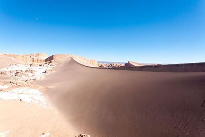 Panoramic view of desert against clear blue sky