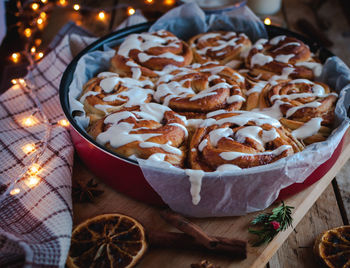 Homemade cinnamon rolls with cream cheese icing, on wooden background