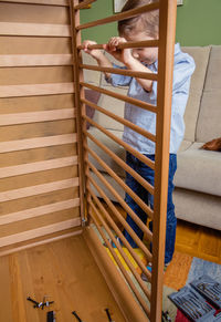 Rear view of girl sitting on bed at home