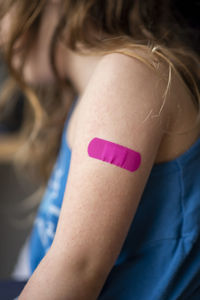 Little girl with a band-aid on her hands, vaccinated against coronavirus infection. vaccination