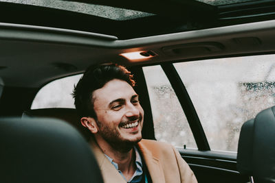 Close-up of happy businessman traveling in car