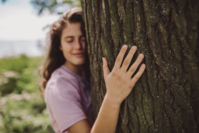 Portrait of woman against tree trunk