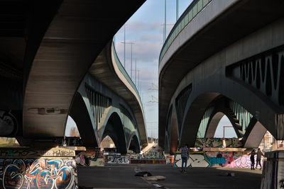 People skating under a bridge