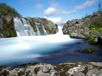 Scenic view of waterfall against sky