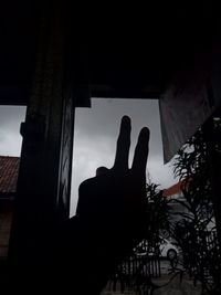 Low angle view of silhouette hand against sky