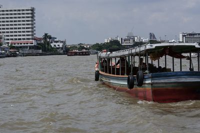 Boat in sea against sky in city