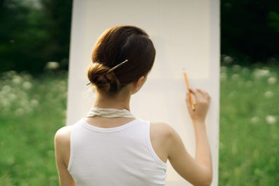 Rear view of woman holding plant