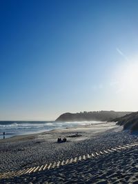 Scenic view of beach against clear blue sky