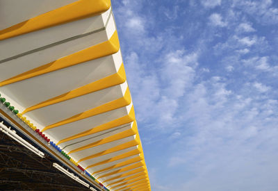 Low angle view of yellow flag against sky