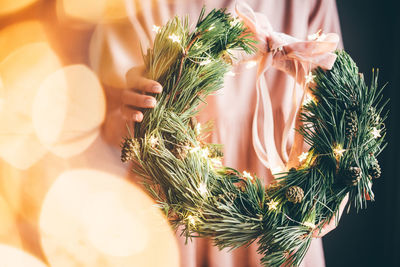 Close-up of woman holding pine decoration