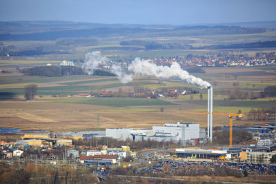 Aerial view of factory in field against sky