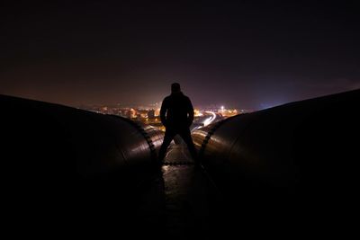 Rear view of a silhouette man standing at night