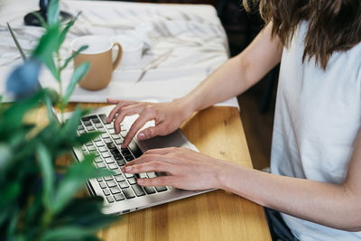 Beautiful woman in the kitchen working on a laptop.