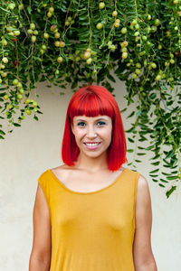 Portrait of smiling woman standing against plants