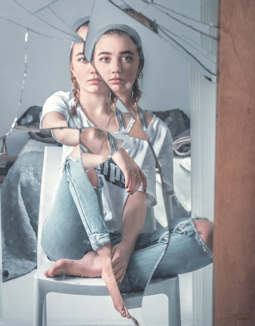 Portrait of young woman reflecting in broken mirror