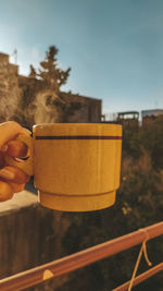 Close-up of hand holding food against sky