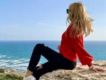 Woman looking at sea against sky