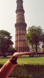 Midsection of woman holding tower against clear sky