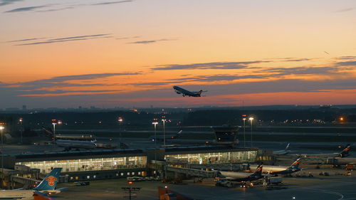 Airplane flying in sky at sunset