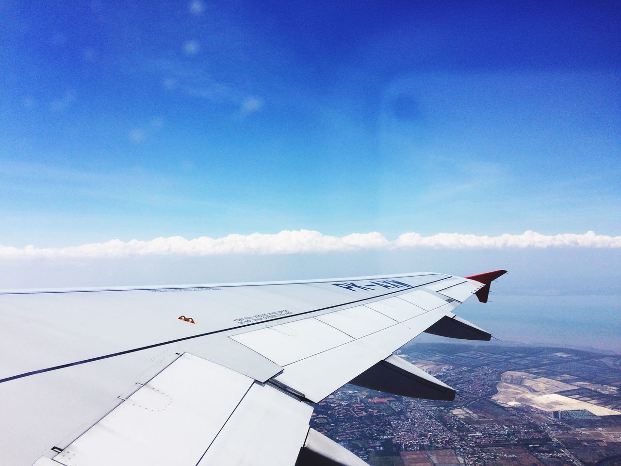 flying, airplane, air vehicle, transportation, blue, mode of transport, sky, mid-air, aircraft wing, part of, travel, cloud - sky, cloud, low angle view, cropped, on the move, journey, outdoors, day, nature