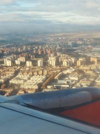 Aerial view of city against sky seen from airplane window