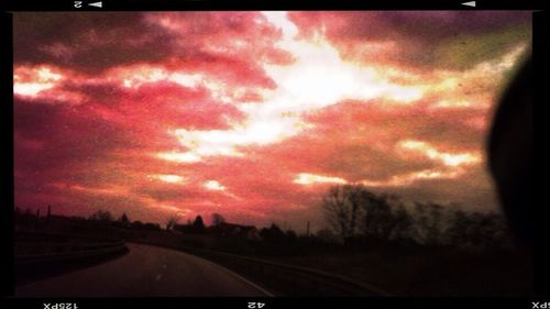 View of road against cloudy sky at sunset