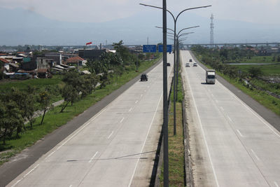 Road by city against sky