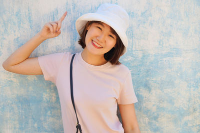 Portrait beautiful woman wearing hat standing against wall