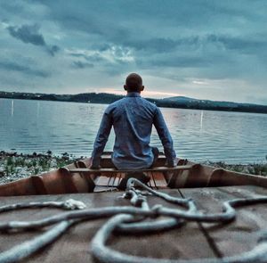 Rear view of man looking at sea against sky