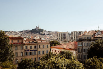 Buildings in city against clear sky