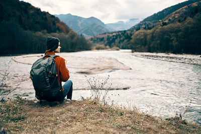 Man sitting on rock looking at land