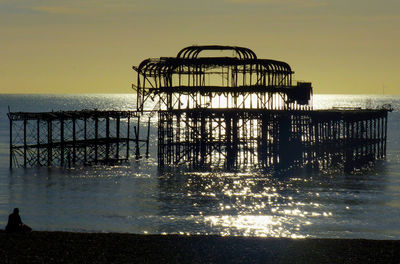 Silhouette pier on sea against sky at sunset