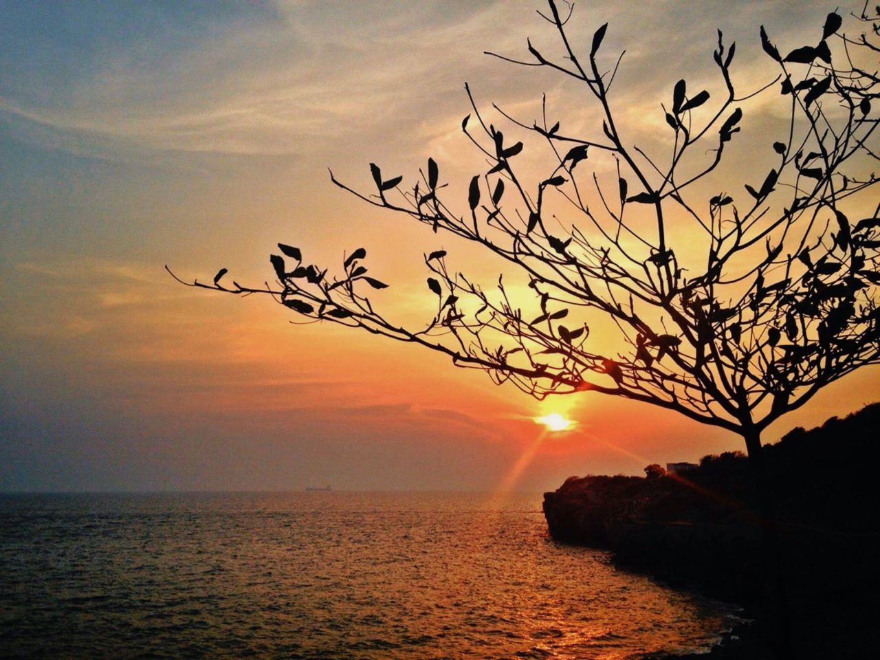 SCENIC VIEW OF CALM SEA AGAINST ORANGE SKY