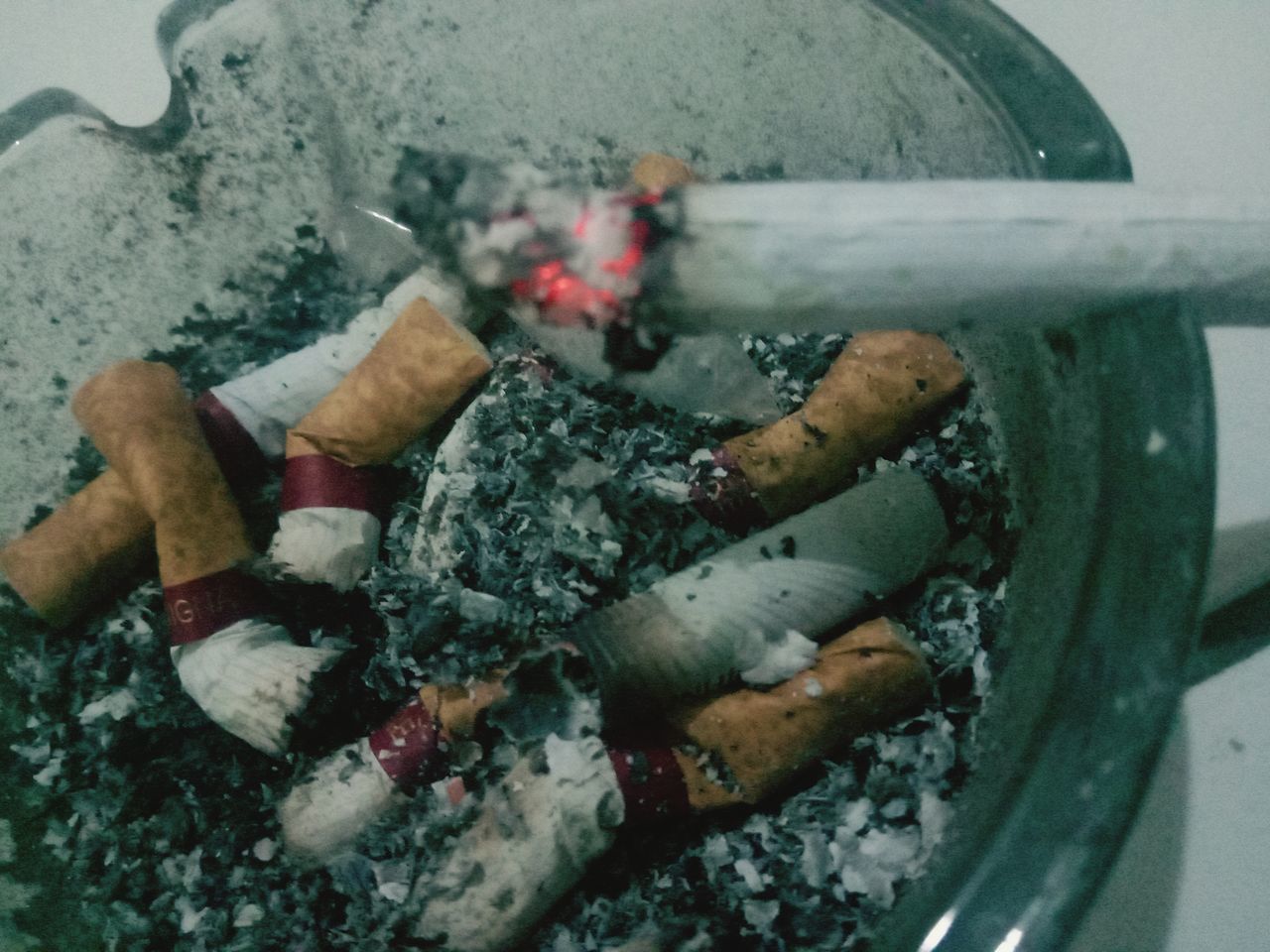 CLOSE-UP HIGH ANGLE VIEW OF CIGARETTE SMOKING