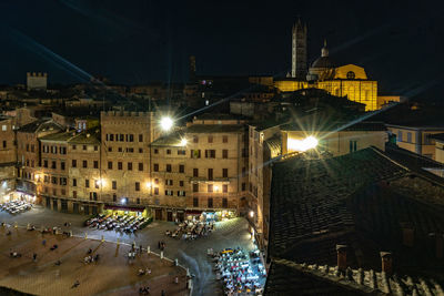 High angle view of illuminated street against buildings at night